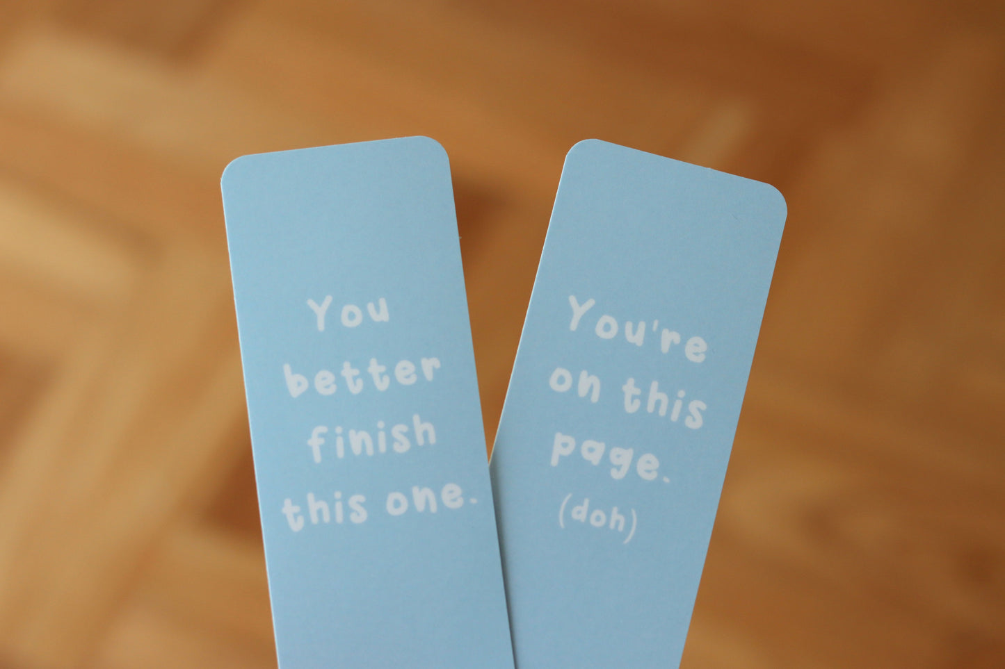 Two blue bookmarks with the text: You better finish this one and You're on this page (doh)