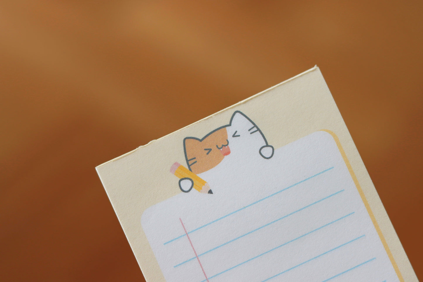 A yellow notepad with a cat and a yellow pencil