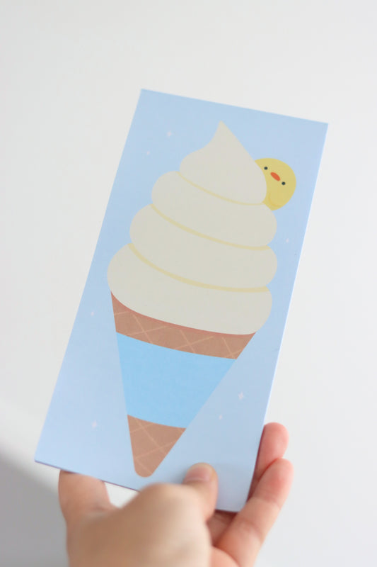 Hand holding a rectangle shaped light blue note pad with an ice cream design